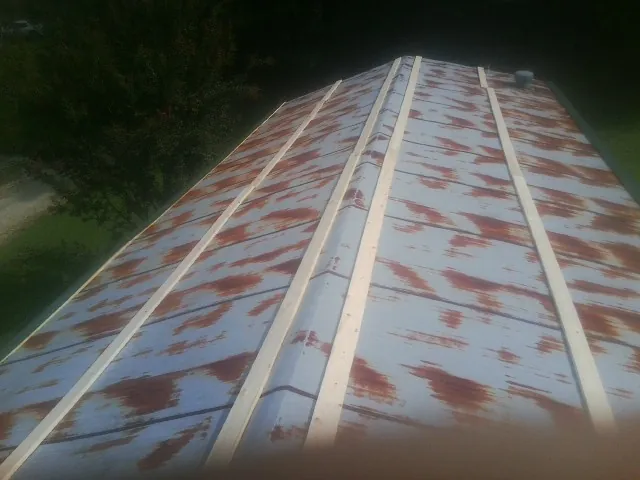 Rusted metal roof panels with new wood purlins before replacement — Storm Damage Roof Repair in Bancroft by Roofing Brothers